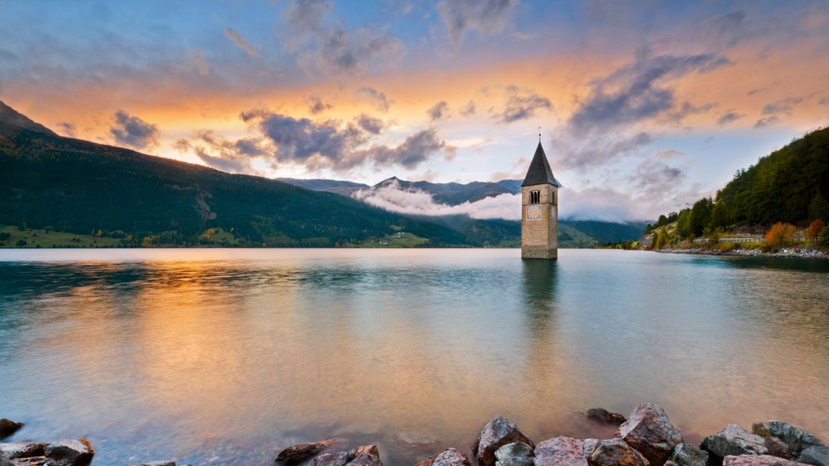 This mysterious-looking bell tower rising from Lake Reschen in the #ItalianAlps is all that remains of the village of Graun. It was submerged in 1950 when an electric company built a dam that flooded the area. #Italy