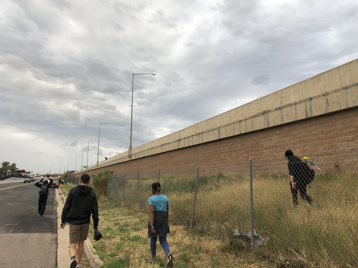 People are now exiting 225, and the crowd has splintered a bit. This is what the side wall of the highway looks like. So not a small fall for the woman. I am close to her now and she appears conscious and breathing, but she is clearly hurting.