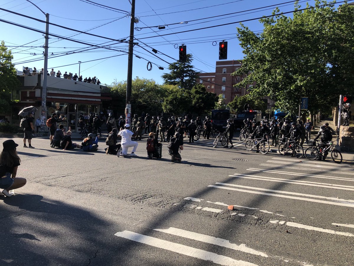 AmyMorenoNews's tweet photo. This group is kneeling in front of officers at the intersection of Harvard and Pine https://t.co/20DKoMXhsA