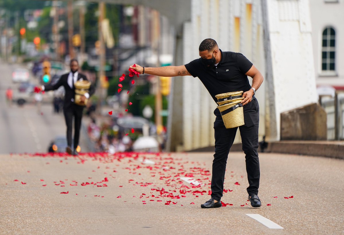 Men scatter rose petals representing the blood spilled on Bloody Sunday on the Edmund Pettus Bridge, before the start of the procession of Rep. John Lewis in Selma, Alabama.

📷 Elijah Nouvelage / Reuters
