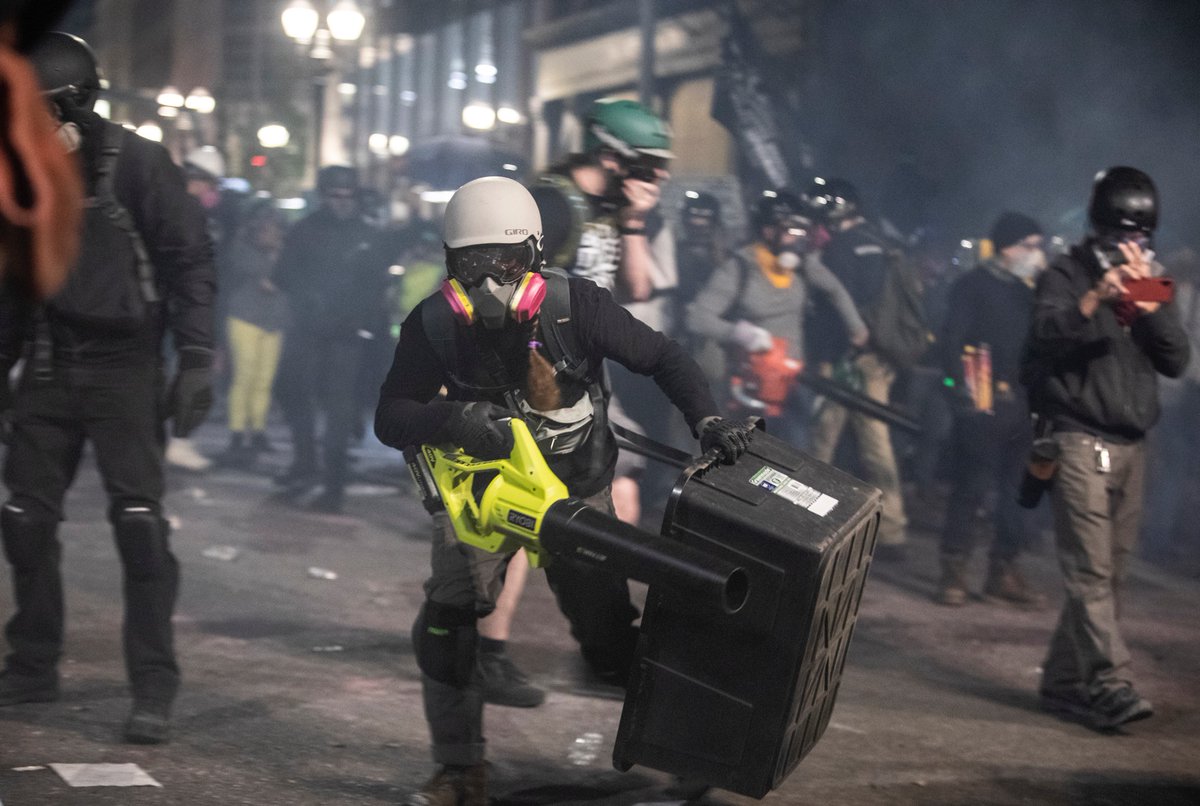 Events picked up as protesters banged and shook the fence. Tear gas canisters were thrown over and back again. Protesters used laser pointers on a spotter that was positioned high up.