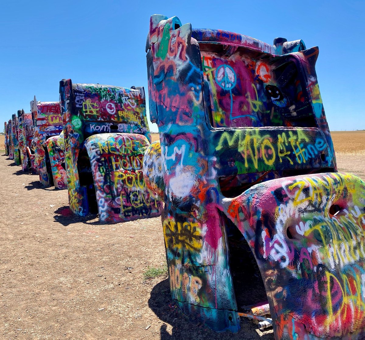 inviteadventure's tweet photo. Passing through #AmarilloTX &amp; want to see ten #Cadillacs buried nose-first in the ground? This #roadsideart attraction, known as #CadillacRanch, has been around since 1974 and is open 24 hours a day for visitors to admire &amp; participate in adding fresh layers of spray paint!😉 https://t.co/7s1asq1BFM