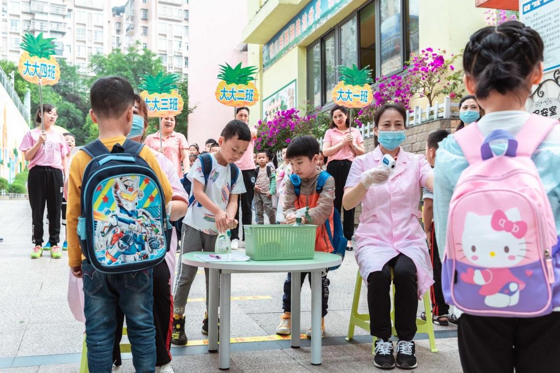 Children get their temperature checked and use hand sanitizer before entering their kindergarten, which reopened on 2 June in Chongqing,  #China. UNICEF supported a Safe School Return campaign to support students, teachers and parents with practical tips.  @UNICEFEducation