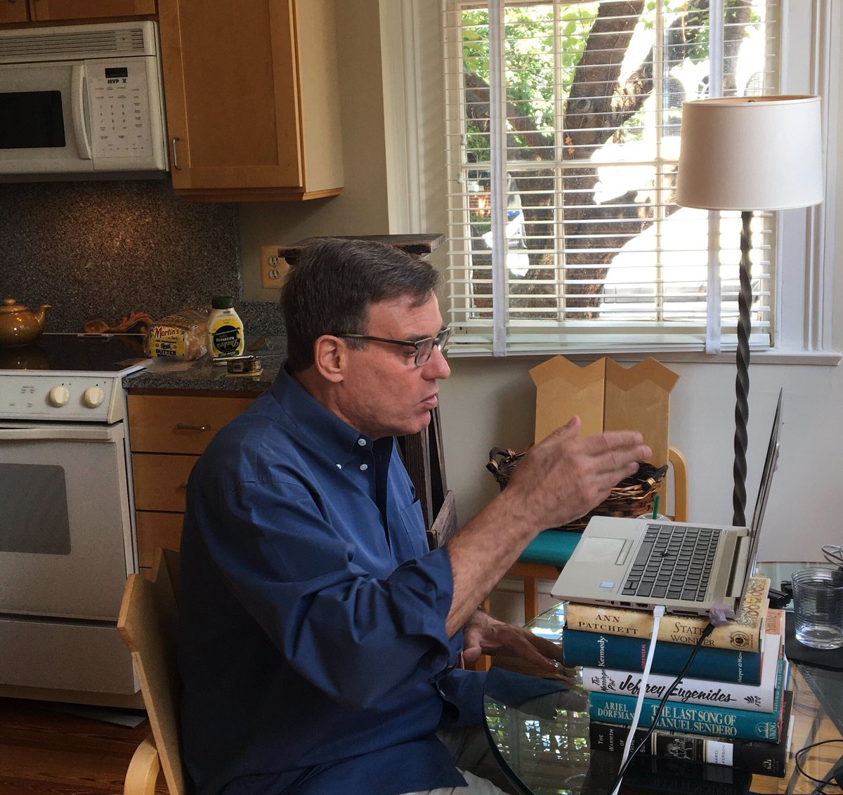 Mark Warner gestures with his right hand as he participates in a Zoom video call.