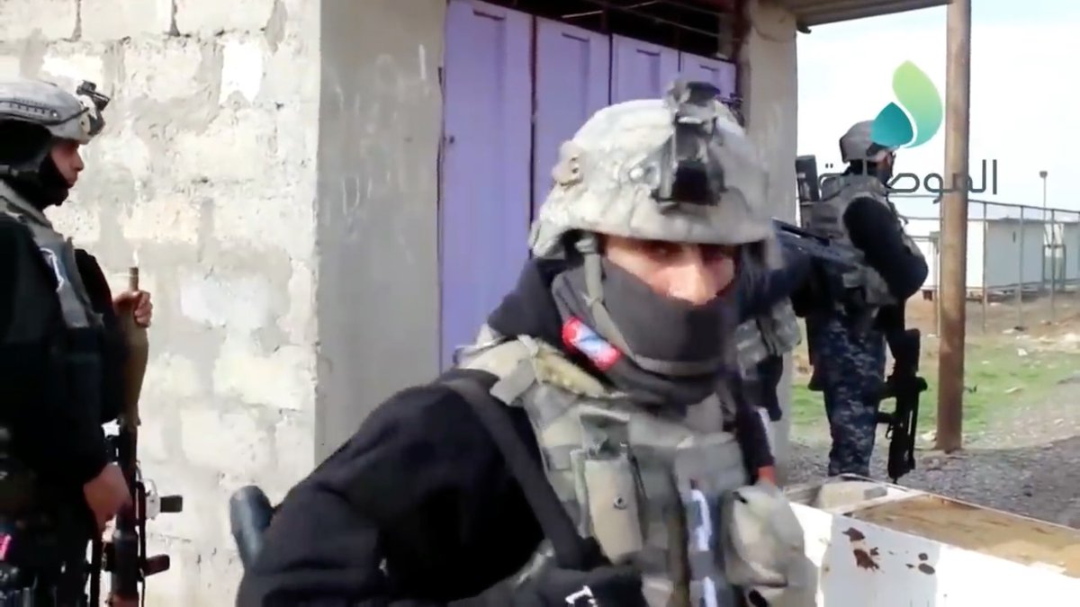 The cameraman is a federal police officer.Suddenly the man in the foreground makes eye contact with cameraman and unslings his rifle.