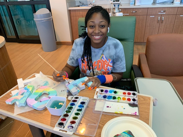 Cure4thekids's tweet photo. More #WorksOf Art... 19-year old Kelis paints the word #Imagine that will be a part of a collective piece created for #CircusCouture. Kelis calls the gang at C4K "family" #C4KSavesLives #ProjectImagine #ProjectImagine #CreativeKids #ArtsInMedicine #ArtsInHealthcare #ArtHeals https://t.co/dq2wgY90zl
