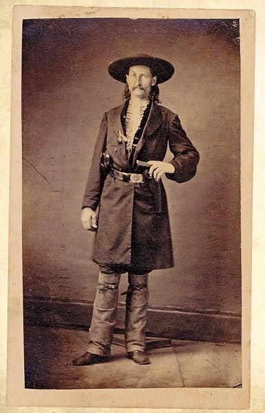 Some have claimed that it became popular after Wild Bill Hickok, who was said to wear two Navy Colts butt first in his red sash. This is the reason Kevin Jarre gives in his Tombstone script for the Cowboy's fashion. But of the many photos of Hickok, none show him with a sash...