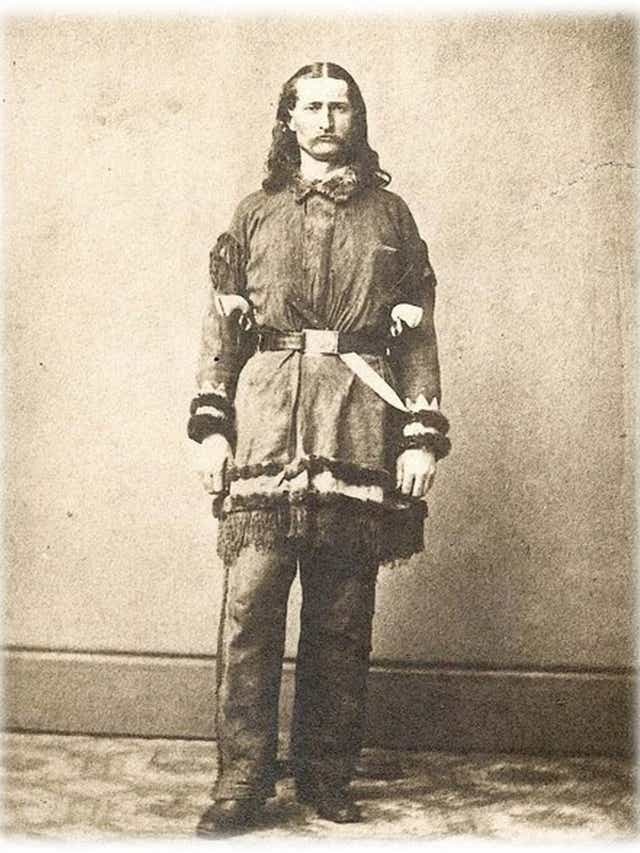 Some have claimed that it became popular after Wild Bill Hickok, who was said to wear two Navy Colts butt first in his red sash. This is the reason Kevin Jarre gives in his Tombstone script for the Cowboy's fashion. But of the many photos of Hickok, none show him with a sash...