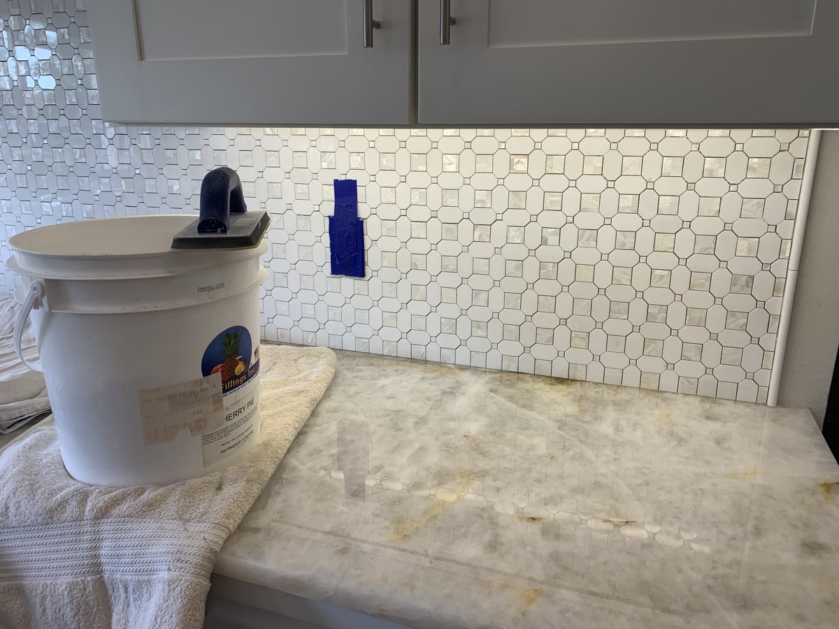 ceramictec's tweet photo. Grouting the geometric pearl white thassos & shell tile backsplash in Tampa, Florida. Caulking and installing the outlet covers. Should have final photos tomorrow #tile #backsplash #geometric #thasso #shelltile #tampa #ceramictec https://t.co/xDB6CibRGm