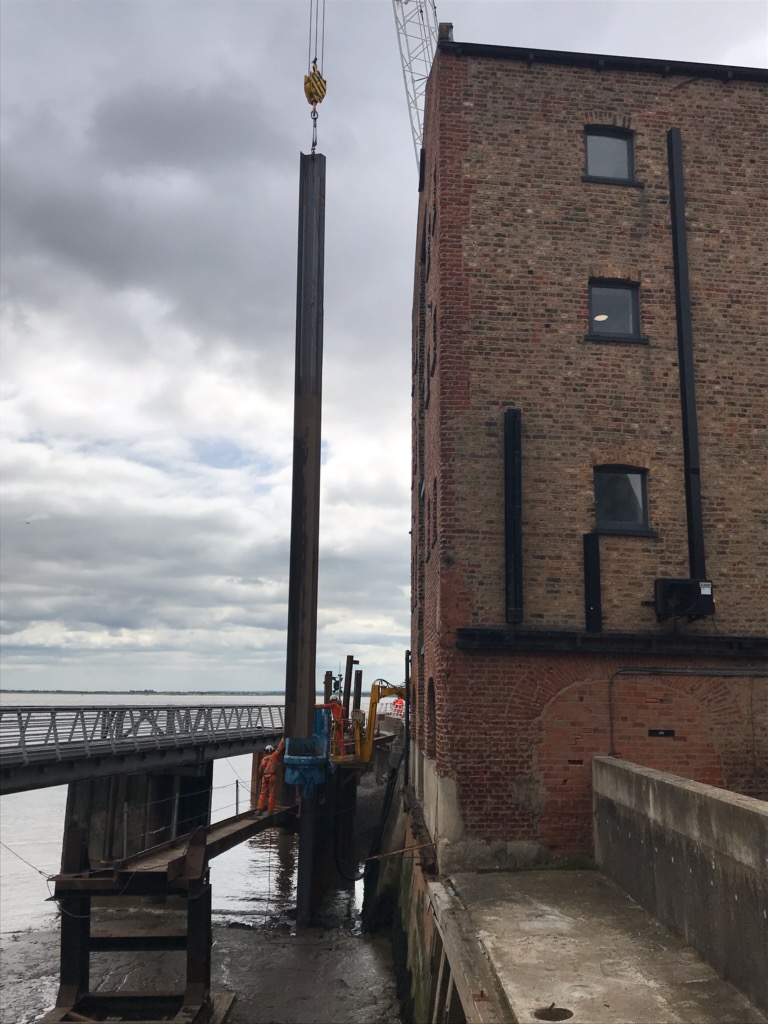 Pile going into giken chuck, ready to drive. Next to the warehouse building at Victoria Pier, on the BAM Nuttall project.