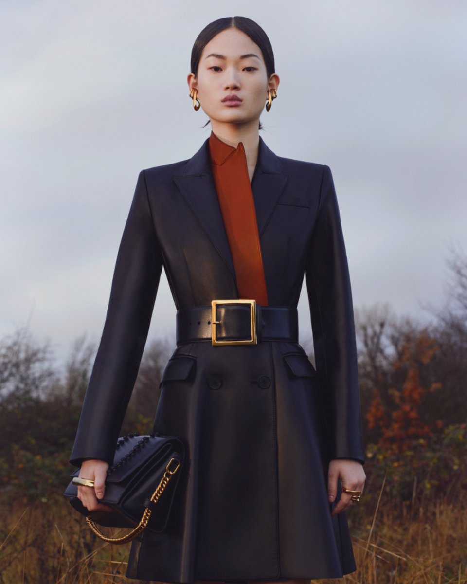 McQueen's tweet photo. A trompe l’oeil black coat with a contrast brown lapel. Worn with the Molten Belt and #McQueenStory Shoulder bag.

Discover the #McQueenPreAW20 collection here: https://t.co/6hvd5lJshU

⁣#AlexanderMcQueen https://t.co/28kfroaD5r
