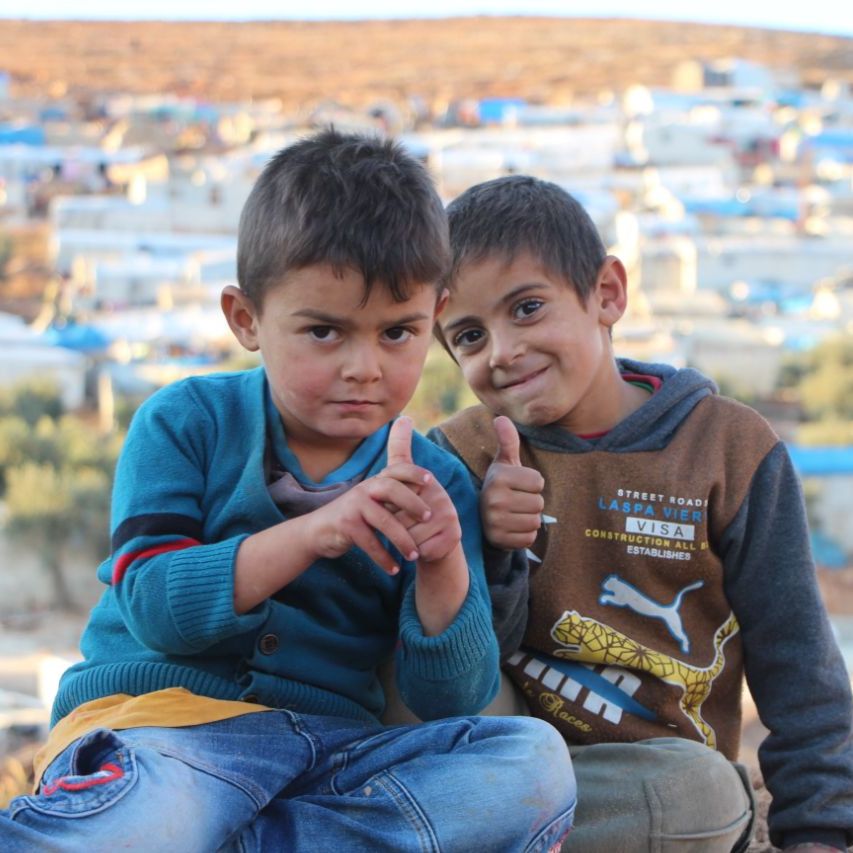 SyriaCivilDef's tweet photo. Their tent is too hot to be inside and the heat is burning outside.  Where can these children go so they can only be children? Their life of Syrian is harsh. Our #WhiteHelmets continue to serve these vulnerable children, hoping for the day when they can return home safely. https://t.co/xCV7eqT4No
