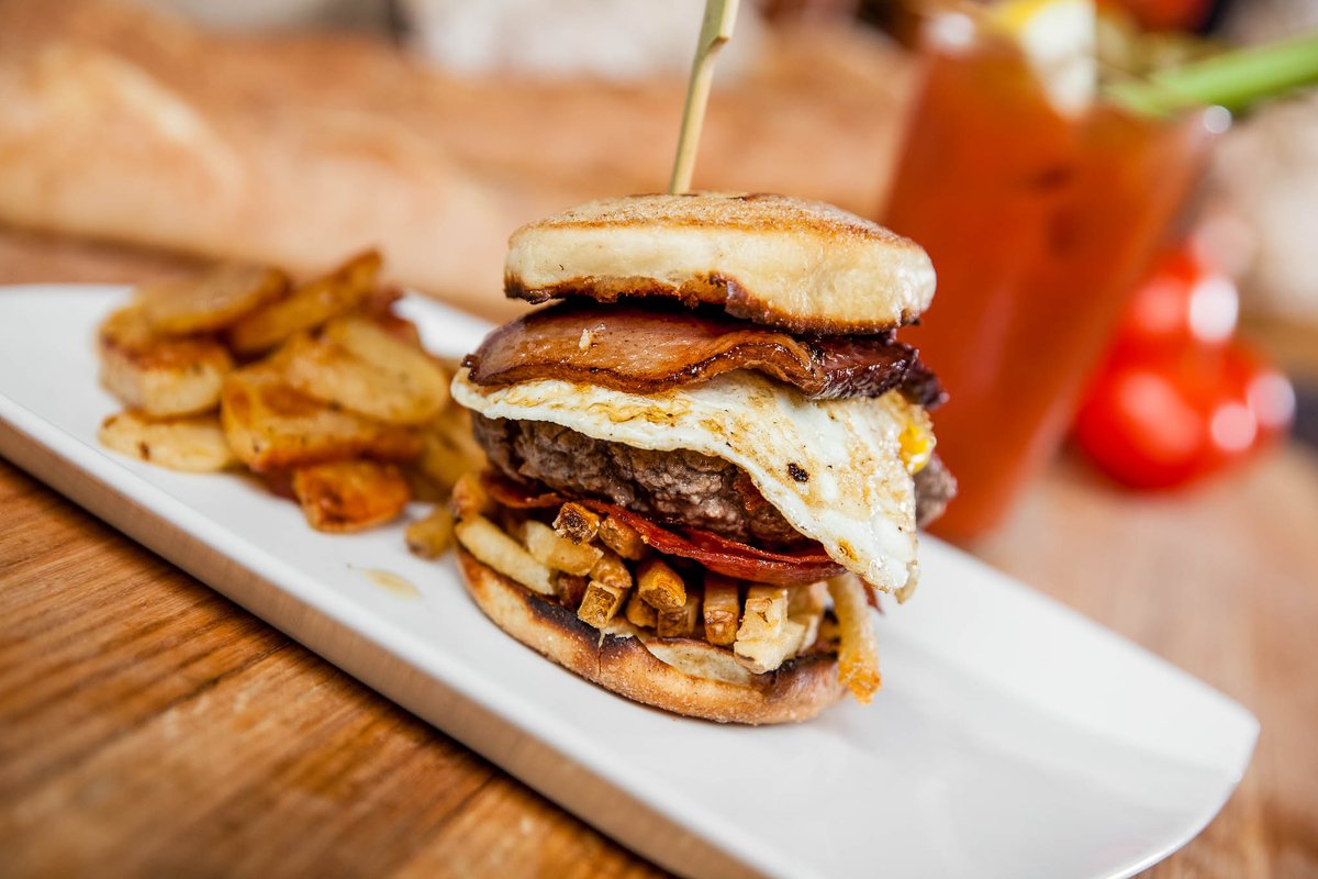 Our Hangover Helper Burger is exactly what the doctor would order this weekend.

Sink your teeth into this masterpiece topped with a fried egg, wrapped in bacon + french fries to boot. You'll feel better almost instantly.

Stop in for indoor or patio dining this weekend.