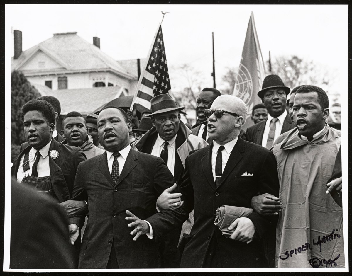 Black and white photo of men marching in a civil rights demo