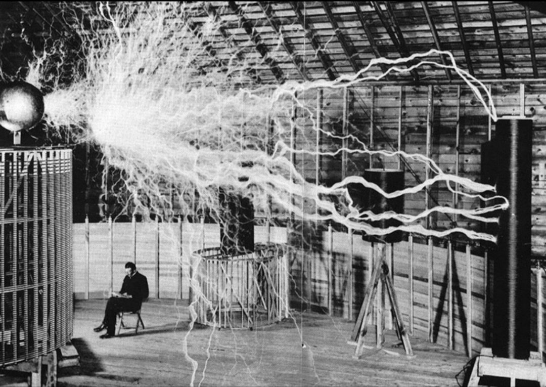 4. Nikola Tesla Duduk di Laboratoriumnya. "Magnifying Transmitter” atau Pemancar Pembesaran adalah salah satu Kumparan Tesla yang pernah Dibuat. (Foto Diambil dengan Bukaan Ganda)