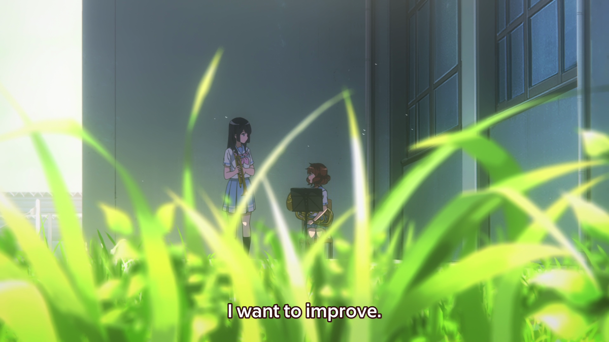 This has to be one of my favorite shots ever. Grass typically symbolizes growth and Kumiko is framed in a grass prison, meaning that Kumiko feels as if her growth is being stunted. She wants to go beyond the grass prison and grow even further, just like Reina who isn't trapped.
