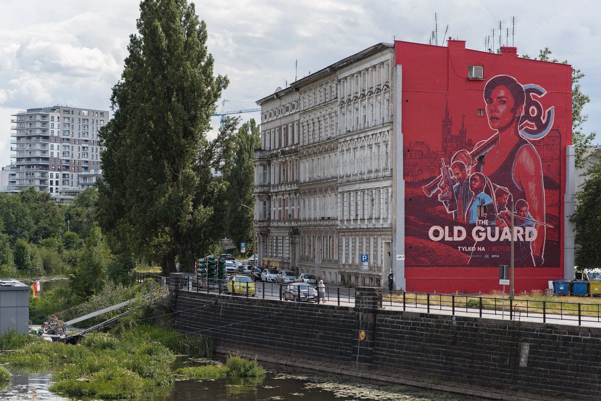 BartoszKosowski's tweet photo. A few pics of my @oldguardmovie murals. The one you can see here is located on Wybrzeze Slowackiego in Wroclaw and it’s background was inspired by a 15th century woodcut depicting the city. Photos by Michał Dziurkowski for #GoodlookingStudio #theoldguardart #theoldguard #mural https://t.co/8CCNdrs0WP