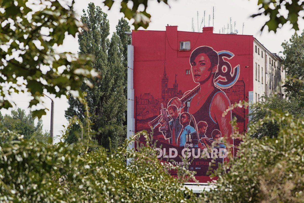BartoszKosowski's tweet photo. A few pics of my @oldguardmovie murals. The one you can see here is located on Wybrzeze Slowackiego in Wroclaw and it’s background was inspired by a 15th century woodcut depicting the city. Photos by Michał Dziurkowski for #GoodlookingStudio #theoldguardart #theoldguard #mural https://t.co/8CCNdrs0WP