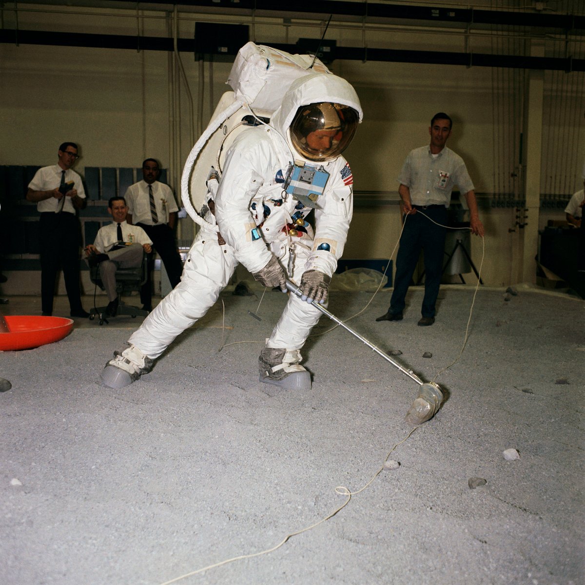 Hora de colocar a coleta de rochas em prática usando os trajes espaciais. Olha só a réplica do módulo lunar Eagle (Águia) lá atrás.