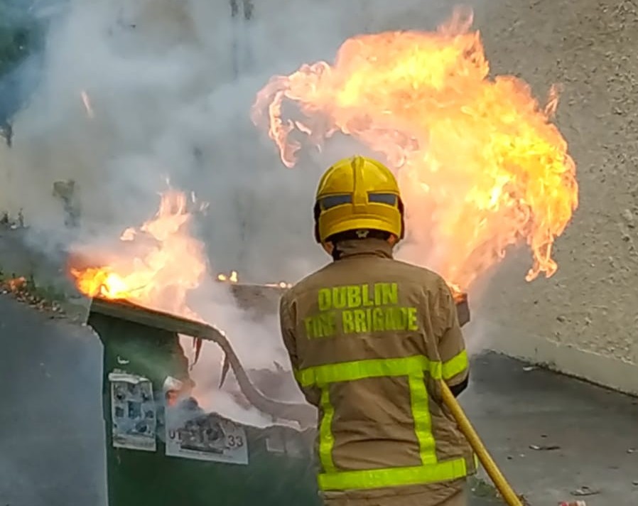 DubFireBrigade's tweet photo. Finglas firefighters dealing with a commercial waste bin fire this evening.

We've attended several of these fires which have spread to nearby gas meter installations.

🔒 Keep bins in a secure area

⚠️ Keep away from gas installations and property

#FireSafety @FireSafetyIre https://t.co/2EKhMS4GjB