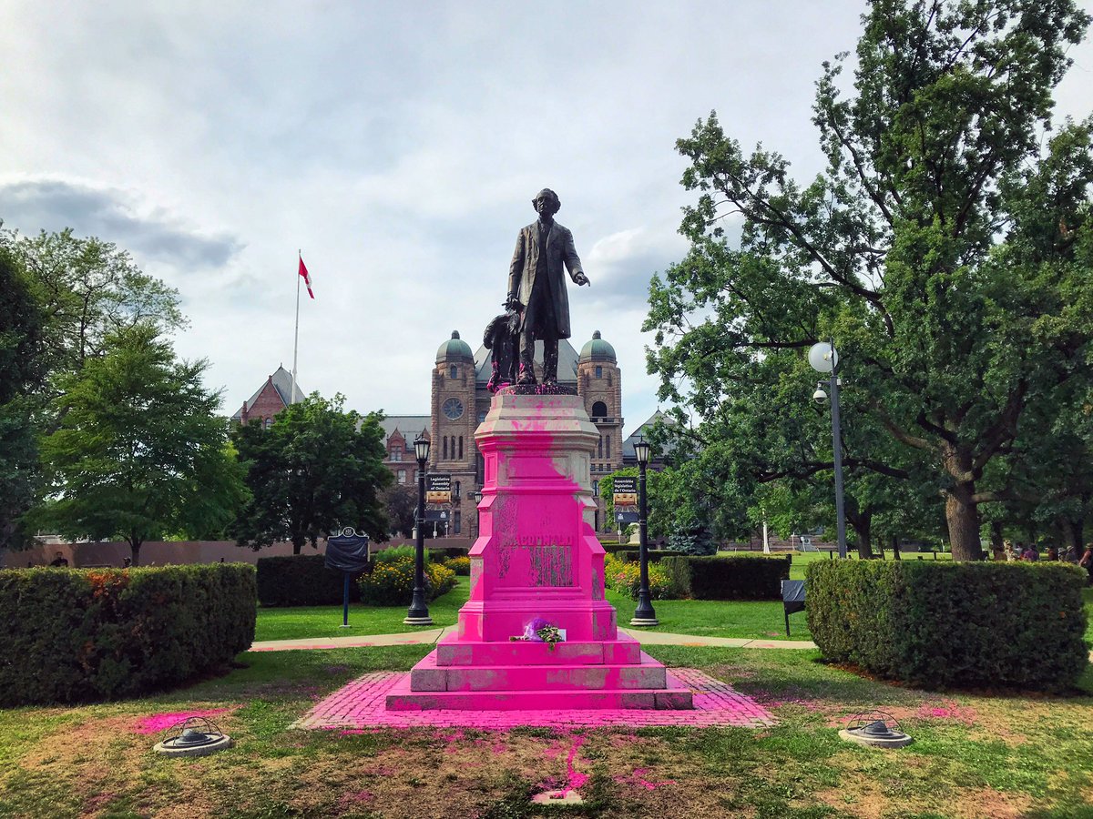 Sir John A. Macdonald has been doused in paint & anti-racist messages at Queen’s Park.The banner reading “Tear down monuments that represent slavery, colonialism and violence” has itself already been torn down.