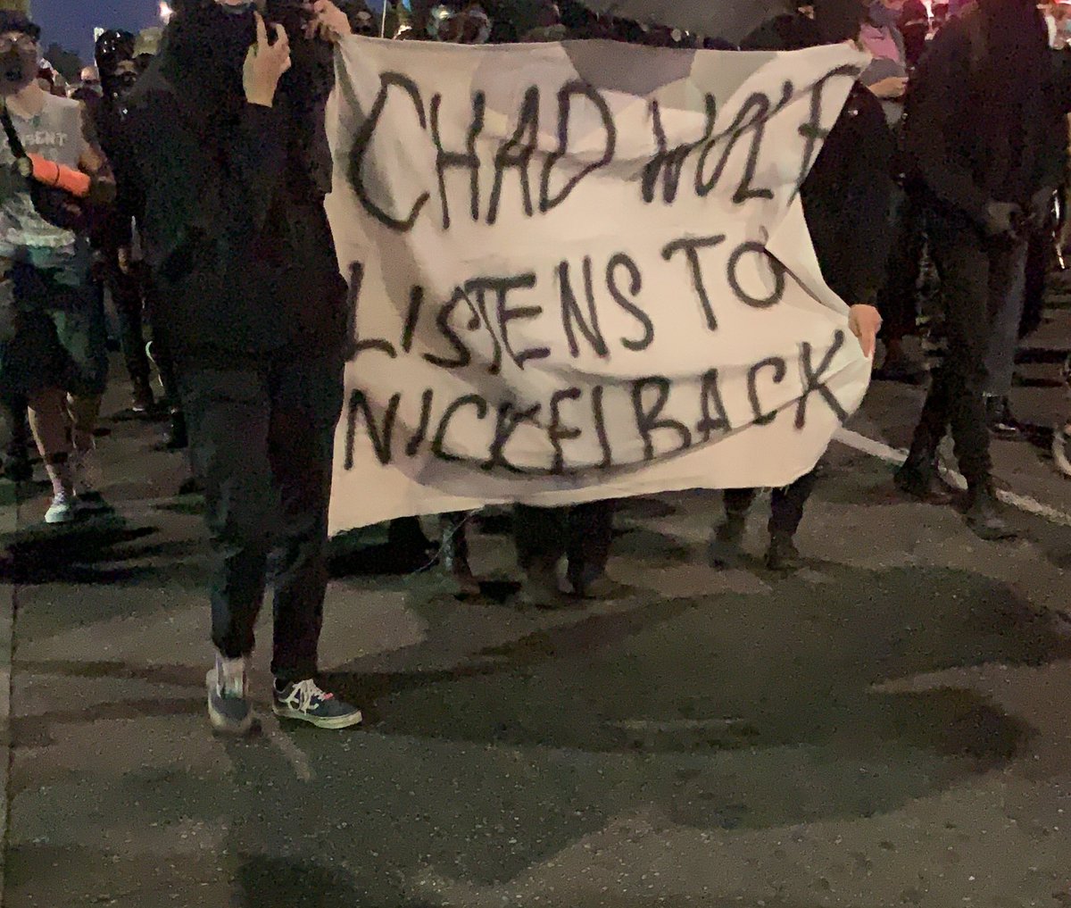 Big banner at the front of the march says “chad wolf listens to Nickelback.” Chad a Wolf is the acting secretary of DHS who claims that the protest is made of “violent anarchists.”