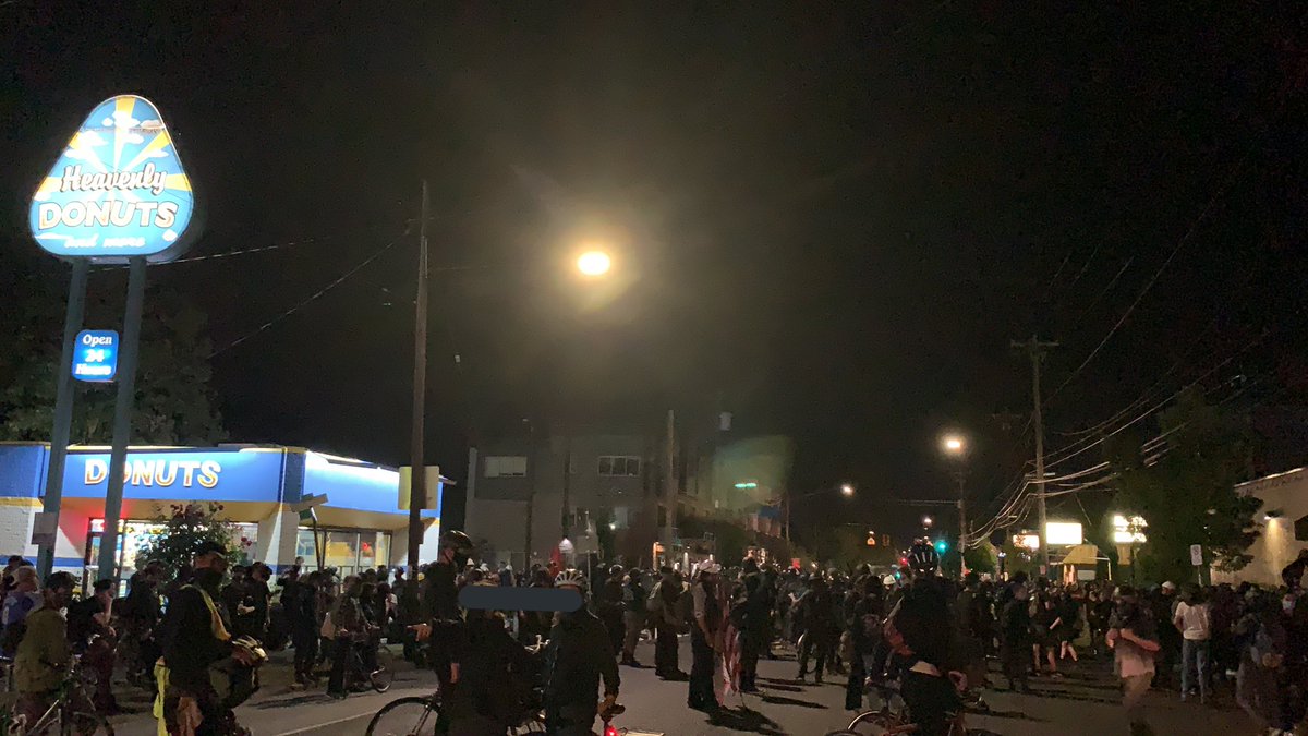 Protesters standing in the middle of Lombard, seemingly unsure of what to do. Someone is drumming.