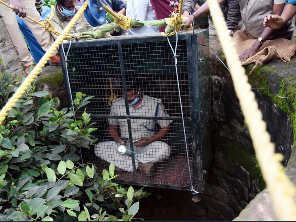 ParveenKaswan's tweet photo. He is Siddarju, RFO from Nagarhole. He entered 100ft dry well to rescue a leopard. By locking himself in a metal cage with a torch and his mobile phone in hand, entered a dry well to rescue a leopard. This is what commitment looks like. Proud of such green soldiers. https://t.co/HBJokpdDOd
