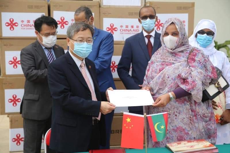 سلم السفير جانغ جيان قوه المواد الطبية في مكافحة الوباء التي تبرعت بها  الأستاذة السيدة بونغ لي يوان حرم الرئيس الصيني شي جينبينغ نيابة شعب الصين إلى الجانب الموريتاني. استلمت المواد الأمينة العامة لوزارة الصحة ومسؤولة لمكتب السيدة الأولي التابع للرئاسة نيابة عن شعب موريتانيا.