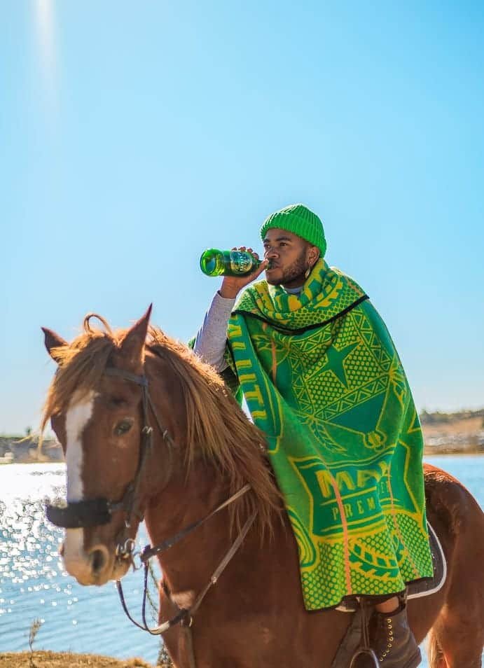 MmMoea's tweet photo. Mosotho horse man proudly on mount a sure footed Basotho pony drinking Maluti beer https://t.co/HGdw0WgiUQ