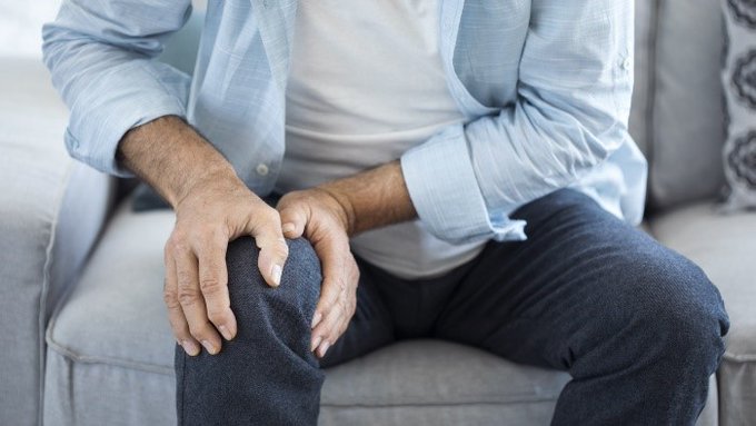 Imagen: Un hombre sostiene su rodilla adolorida.