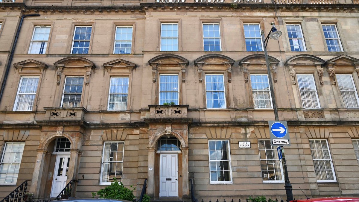 Blonde sandstone terrace with white doors.