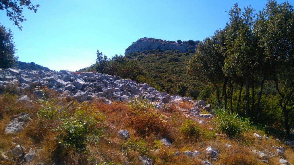 How important Nakovana fort was during the Illyrian times can be seen from the fact that over 50 stone tumuli (cairns) are strewn over the fields surrounding the fort. Like the one on this picture shown with the Grad fortress in the background...