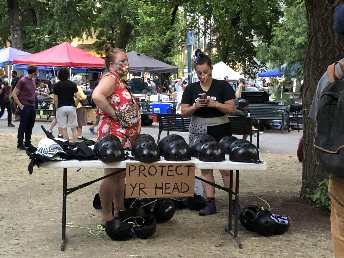 Checking in from Lownsdale Square in downtown Portland, where hundreds are gathered yet again and these community minded folks have free helmets on offer for anyone who wants head protection.