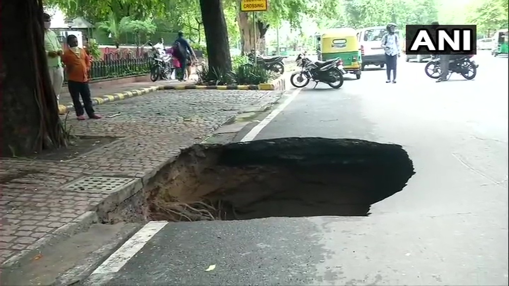 ANI's tweet photo. Delhi: Part of Ashoka Road caved in following heavy rainfall in the national capital region today. https://t.co/WoWgMkSGmA