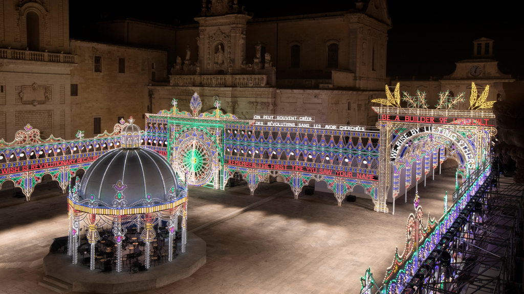Dior's tweet photo. The Piazza del Duomo in Lecce is magically lit up with luminarie, a specialty of the Puglia region, and powerful text art by Marinella Senatore, ready to host the unveiling here and https://t.co/akWsXTLiKd of the #DiorCruise 2021 collection by Maria Grazia Chiuri at 8:45pm CET. https://t.co/ye4zsycuFo
