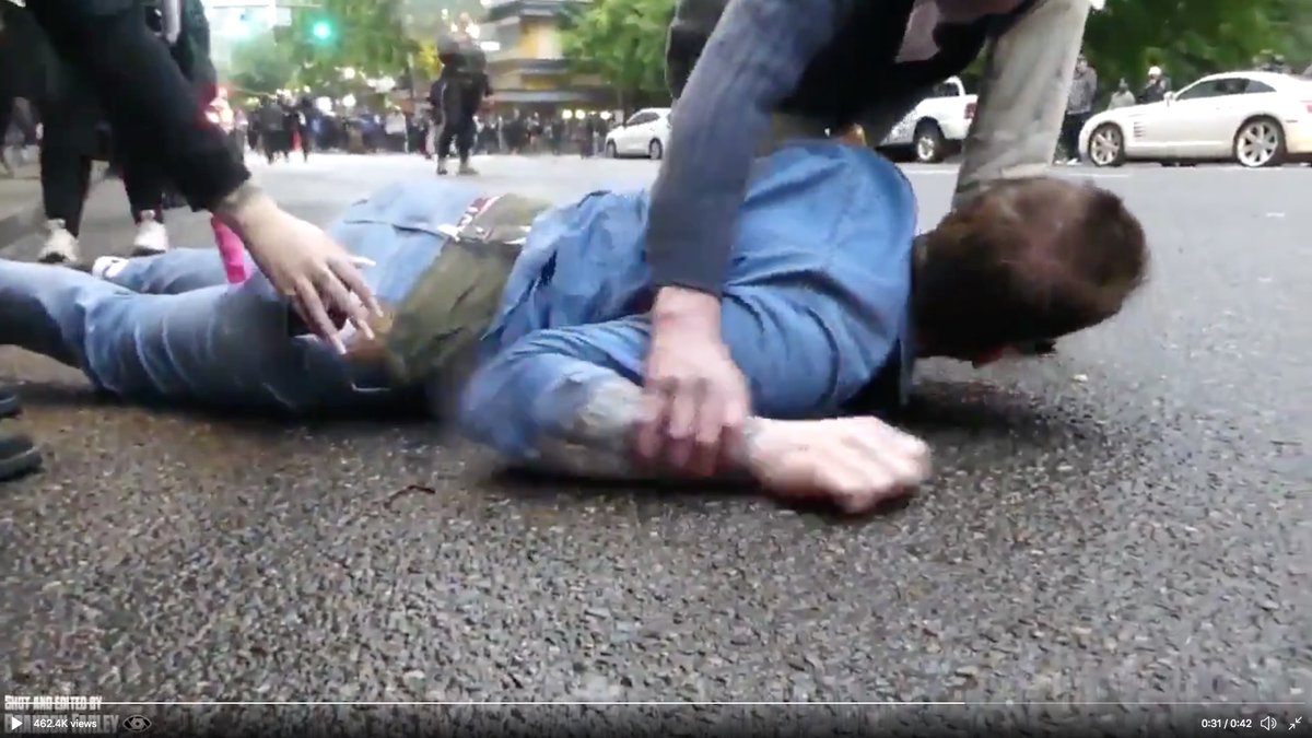 Another hand reaches down and tucks the victims's cell phone into his pocket (left).