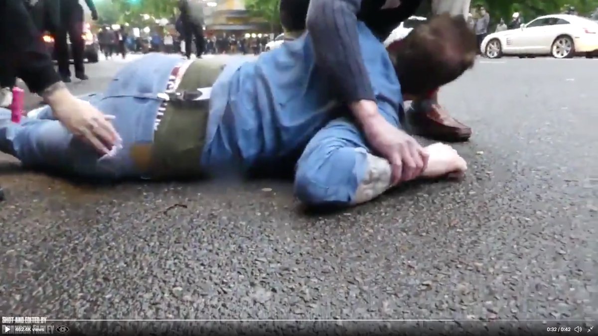 Another hand reaches down and tucks the victims's cell phone into his pocket (left).