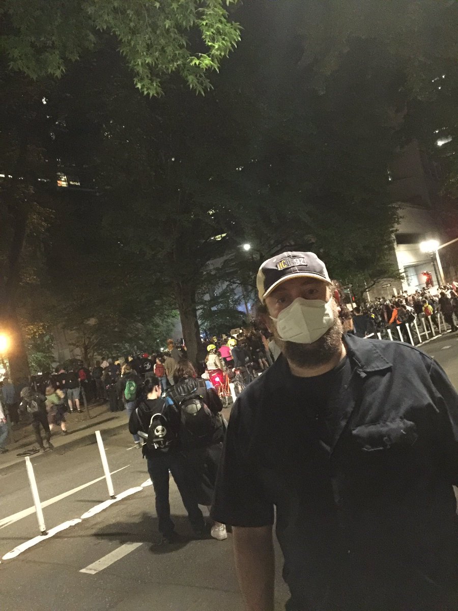 JoshuaSafran's tweet photo. Was at the federal court house in Portland again with my daughter this evening. @tedwheeler spoke, demanding that federal forces end their occupation. All very peaceful etc as usual. Until unidentified paramilitary soldiers began firing on the crowd. #PortlandProtests https://t.co/D2oZo19fFt