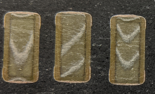 let's look at some interesting details. these scalloped patterns are where i've sliced into the conductive plates. the cut is not parallel to the plates because the capacitors are *soldered* to the lead frame and are slightly crooked!