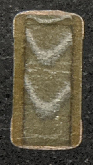 here's a capacitor again up close. you can see alternating layers of conductor and ceramic insulator. also the copper plating on the end caps is readily apparent.