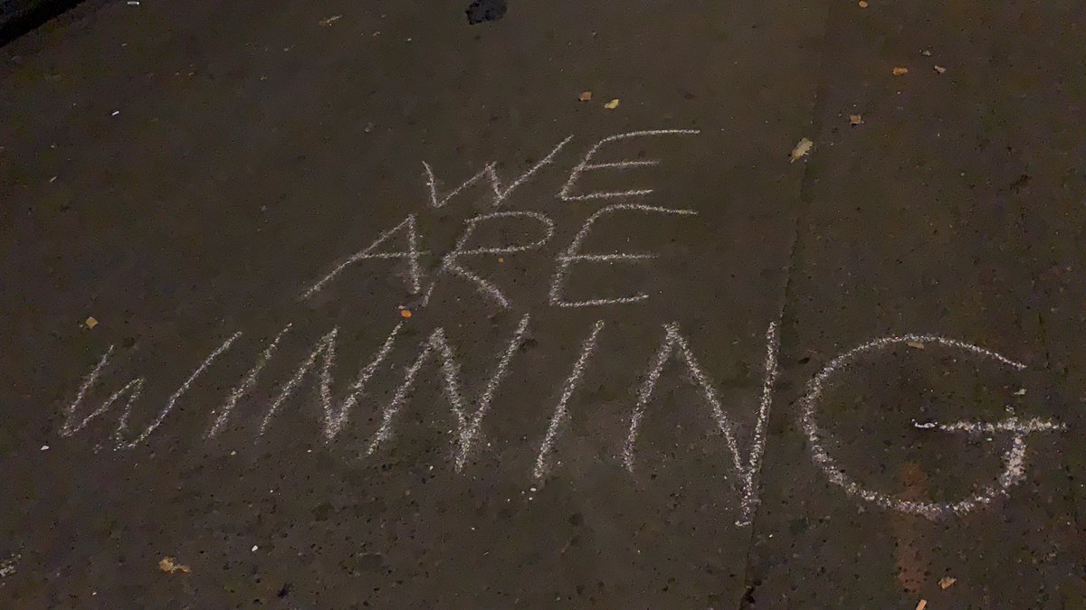 A protester just chalked “we are winning” on the sidewalk