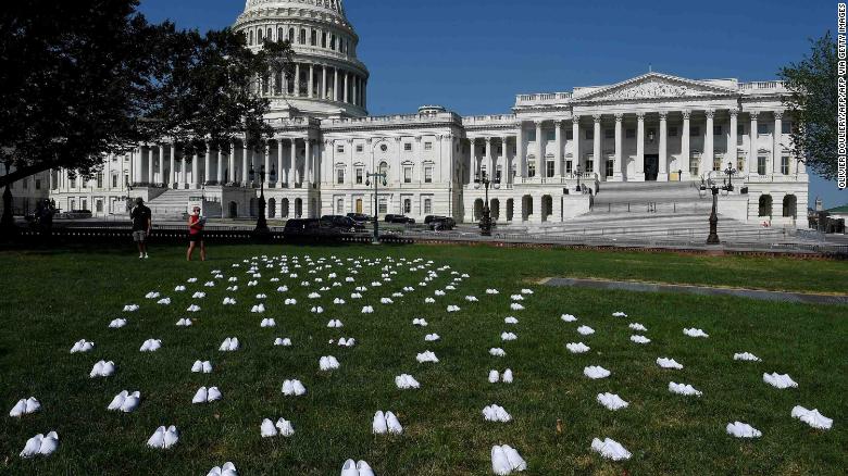 CNN's tweet photo. Over 160 pairs of white nursing clogs lined the lawn facing the US Capitol on Tuesday in memory of the nurses who've died during the coronavirus crisis https://t.co/wnWaDfuV4w https://t.co/l7BPgmBD1E