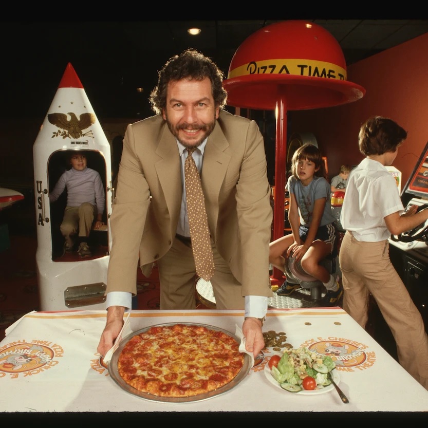 He sketched out a restaurant concept. What cheap food do kids love that takes a while to prepare (during which time the kids can sink quarters into games)?Born was "Pizza Time"