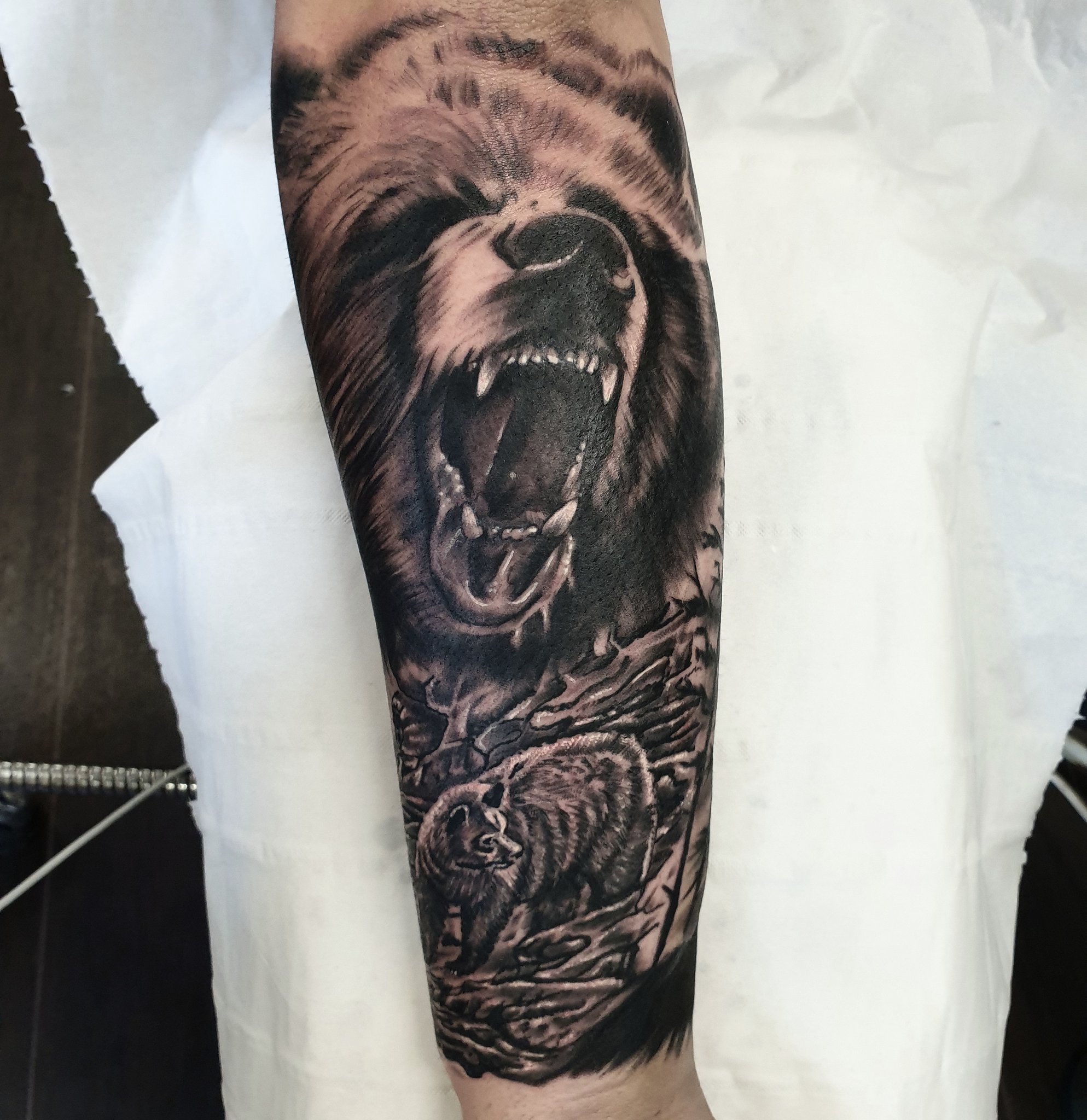 Black and grey bear tattoo on the right inner forearm