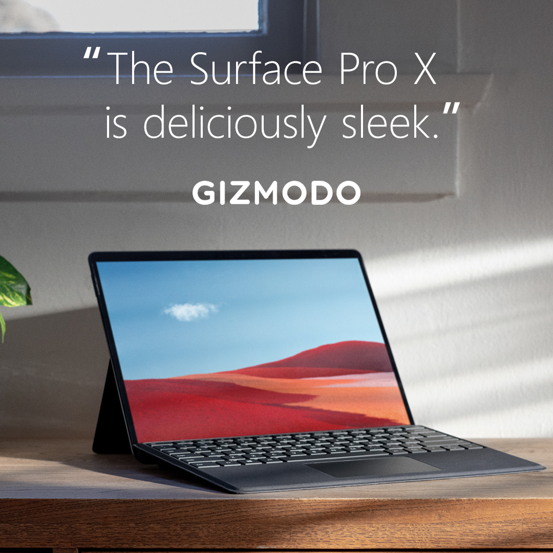A Surface Pro X laptop sits on a desk with its screen open. Text on the image says: "The Surface Pro X is deliciously sleek." Gizmodo