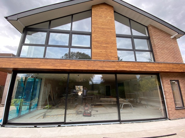 Kommerling 76mm tilt &amp; turn windows in Ulti_Matt black European grade foil accompanied by an 8 meter aluminium triple track patio installed in Wollaton, Nottingham.