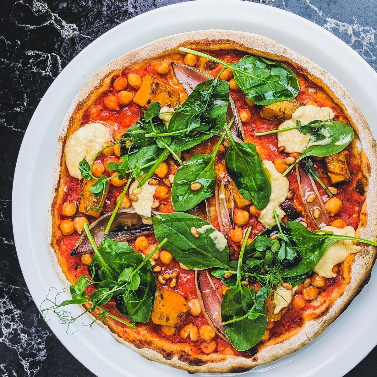 New on the menu this weekend... ⁣
Vegan Butternut Squash, Shallot and Hummus Pizza ⁣
Chilli &amp; cumin butternut squash, roasted shallots and chickpeas with lemon hummus, spinach, coriander and toasted pine nuts⁣
#manchestervegan #vegan #veganfood #veganpizza #veganmanchester