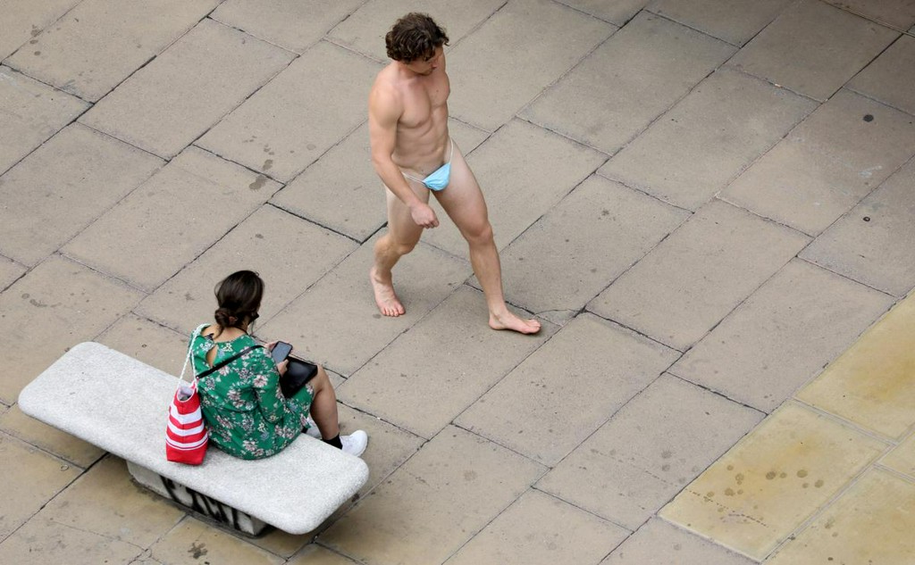 Reuters's tweet photo. Man parades down Oxford Street wearing nothing but mask https://t.co/lcFoeGKCuj https://t.co/pRDD0zzo4V