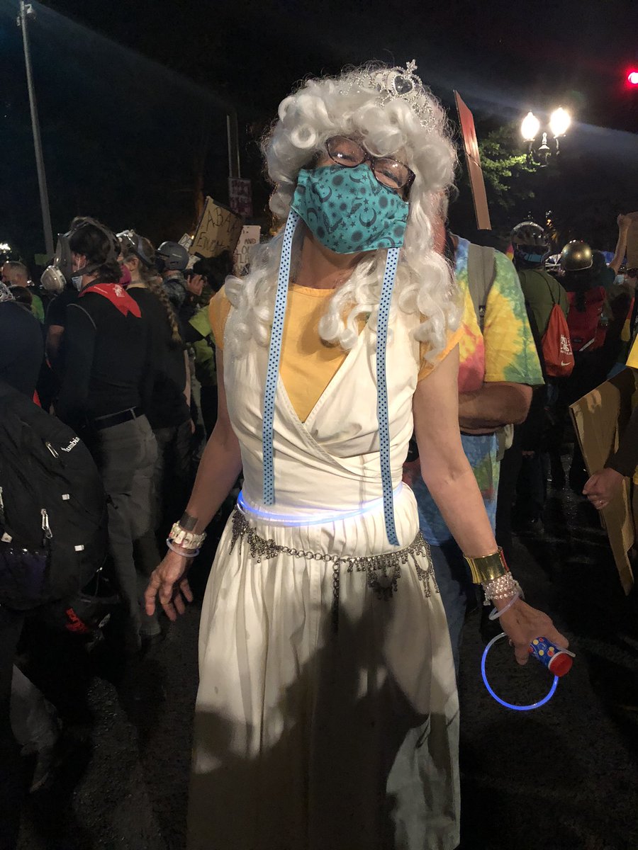 This lady says she’s here as the protest fairy godmother. She’s not a mom, but she is a godmother, so tonight she’s dressed the part for everyone here. When I asked how long she’s been coming out to protest she told me: 50 years.  #PortlandProtests